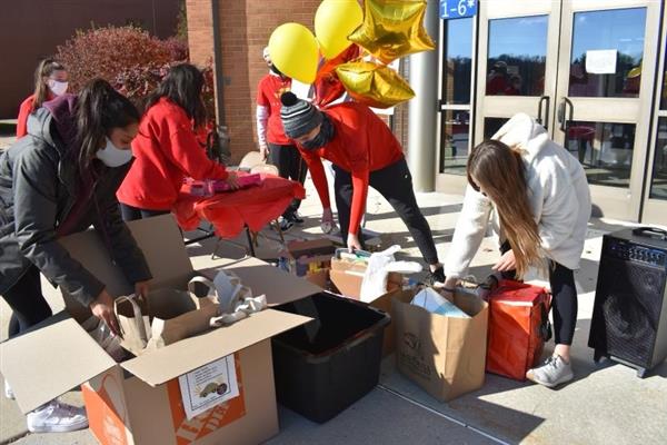 Members of the East High School DECA club collect donations for Home of the Sparrow 